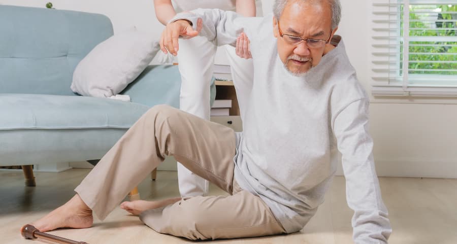 Older man on the floor getting helped up